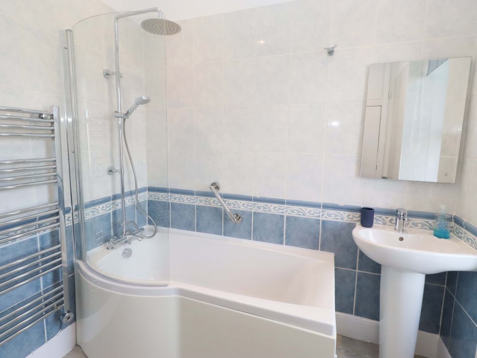 A bathroom with a bathtub and shower unit at Dinguardi in Seahouses