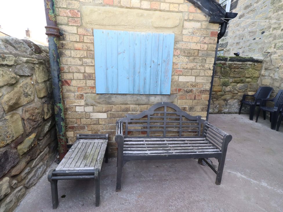 An outdoor area with a bench and table at Dinguardi in Seahouses