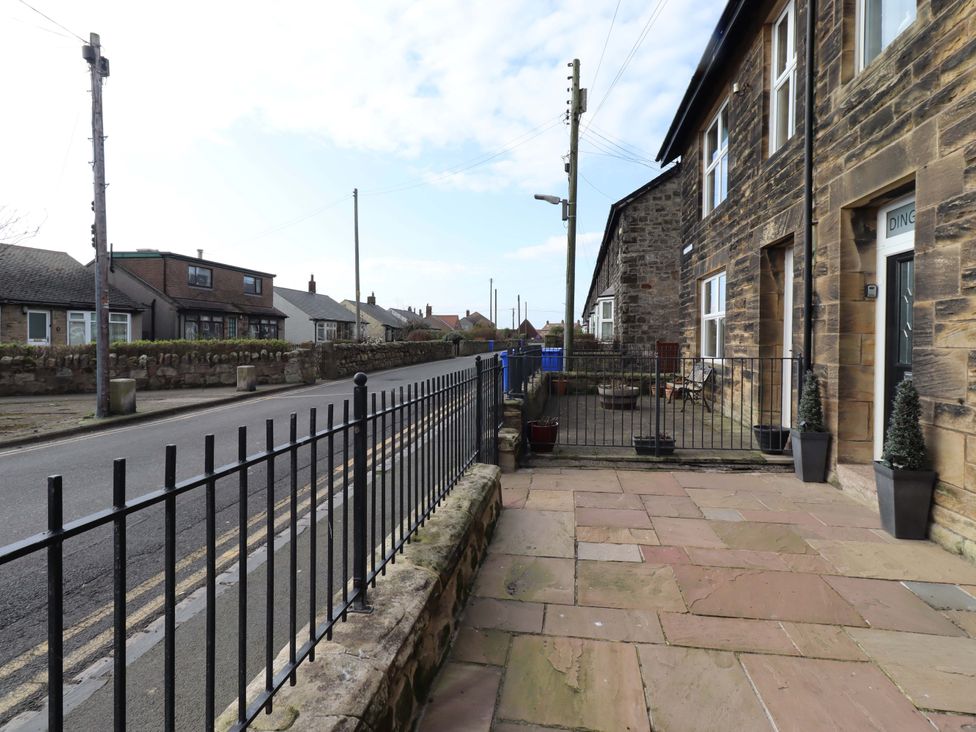 An outdoor area with a stone pathway and fence at Dinguardi in Seahouses