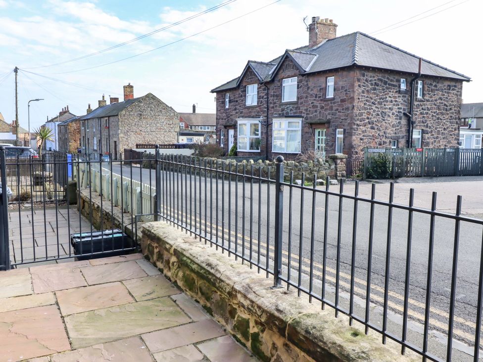 A view of houses and a street from a fenced area at Dinguardi in Seahouses