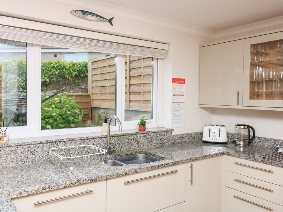 A kitchen with sink, cabinets, toaster, and kettle at Eydon Salcombe