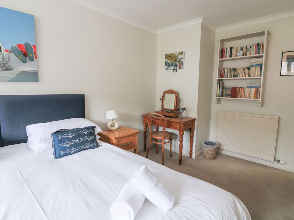 A bedroom with a bed and bookshelf at Eydon in Salcombe