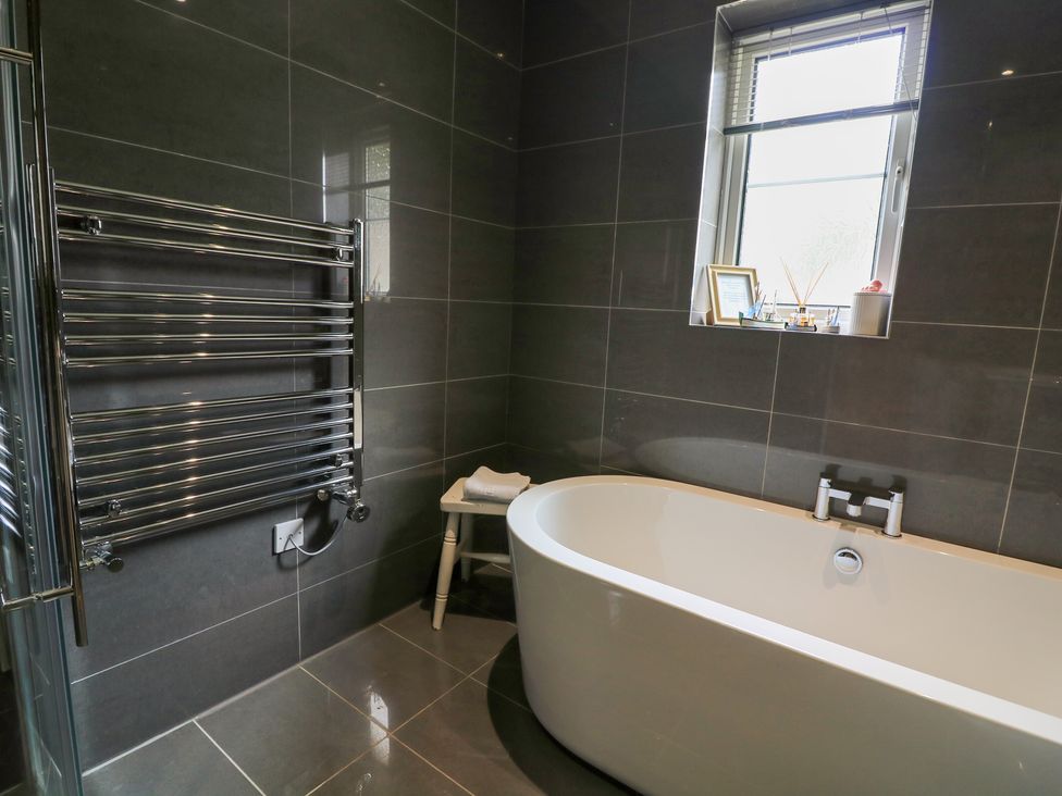 A bathroom with a freestanding bathtub and heated towel rail at Eydon in Salcombe