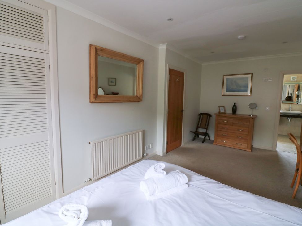 A bedroom with a bed and dresser at Eydon in Salcombe