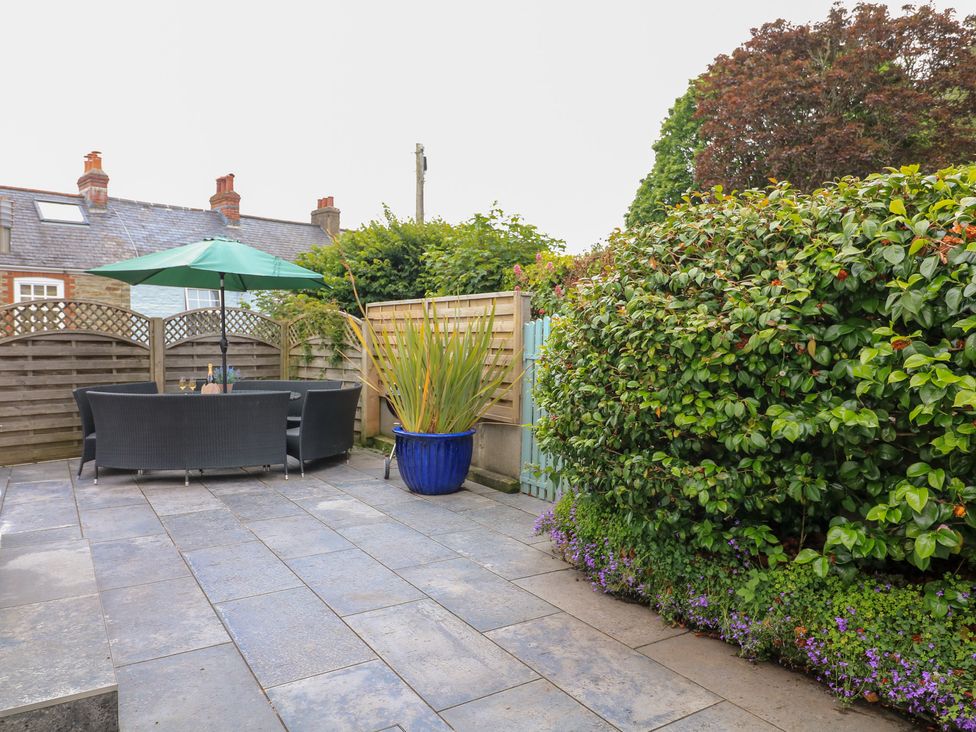 A garden with patio furniture and greenery at Eydon in Salcombe
