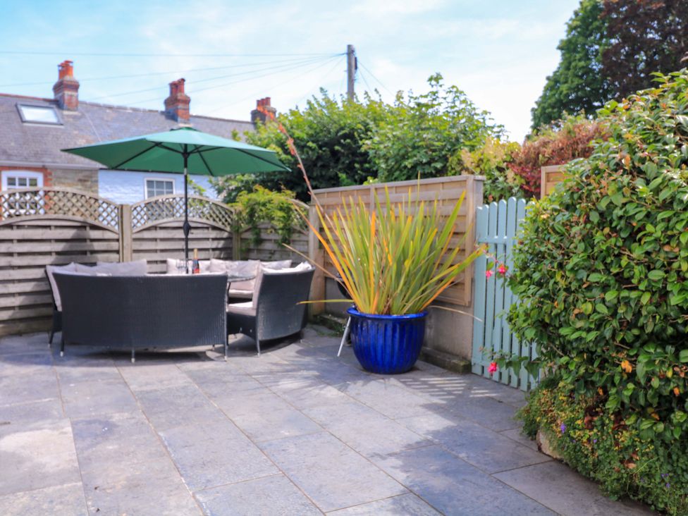 An outdoor seating area with a table and umbrella at Eydon in Salcombe