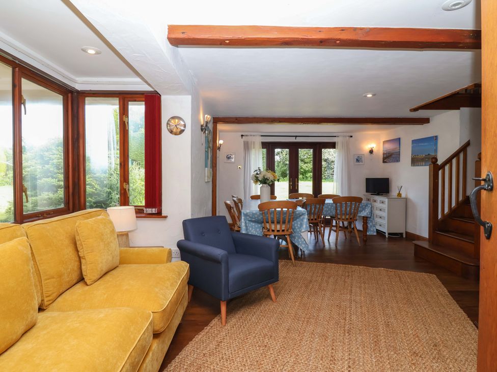 A living room with a sofa and dining area at 1 Eastdon Cottages in Exeter