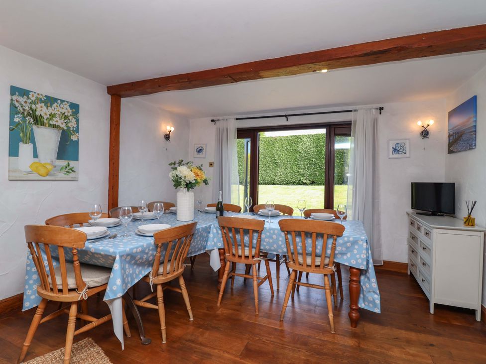 A dining room with a table and chairs at 1 Eastdon Cottages in Exeter