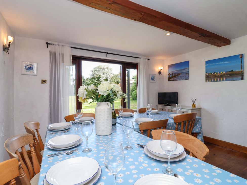 A dining room with a table set for meals at 1 Eastdon Cottages in Exeter