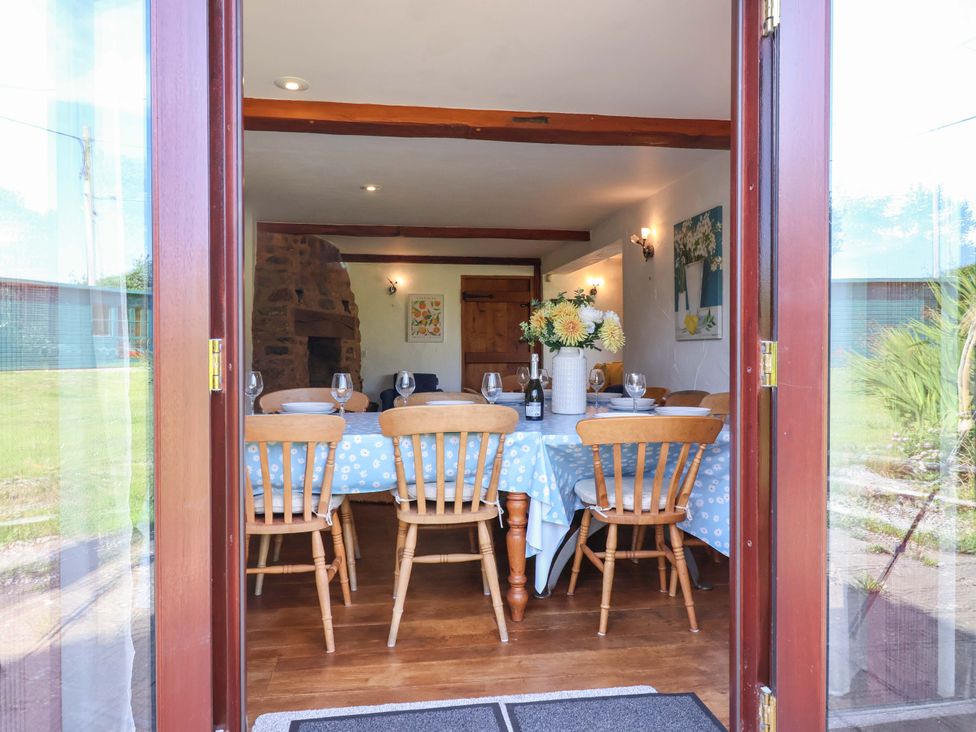 A dining room with a table and chairs at 1 Eastdon Cottages in Exeter