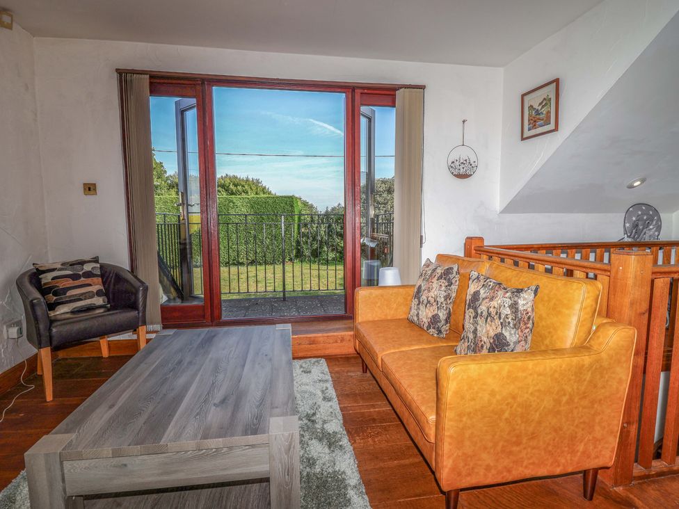 A living room with a sofa and coffee table at 1 Eastdon Cottages in Exeter