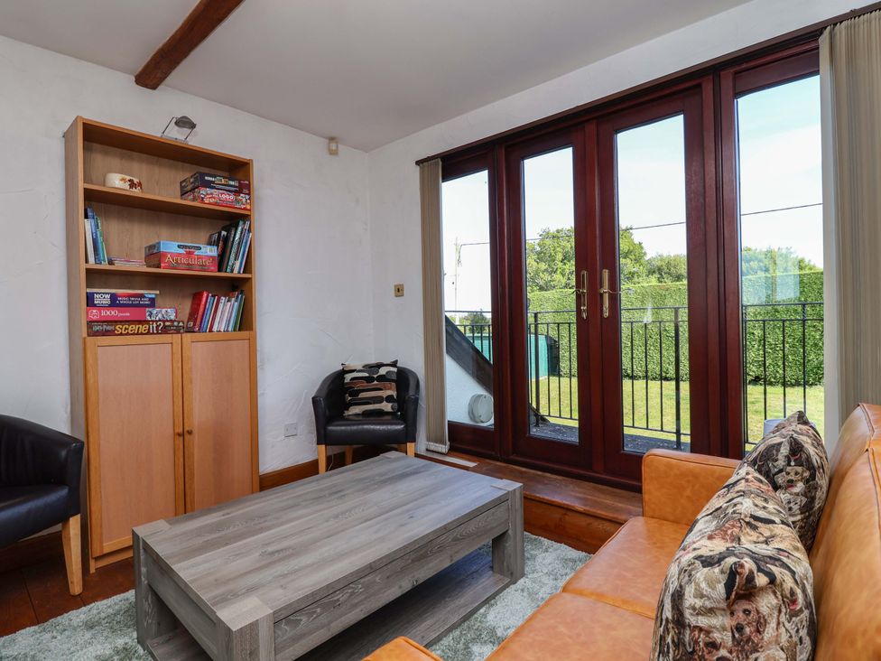 A living room with a bookshelf and coffee table at 1 Eastdon Cottages Exeter