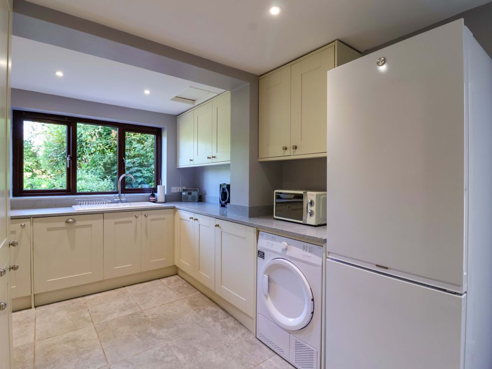 A kitchen with white cabinets and appliances at 1 Eastdon Cottages in Exeter