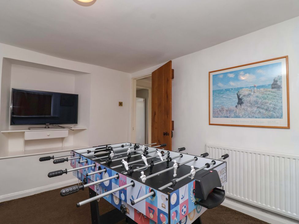 A game room with a foosball table and a television at 1 Eastdon Cottages in Exeter