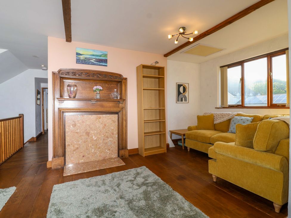 A living room with a fireplace and sofa at 1 Eastdon Cottages in Exeter