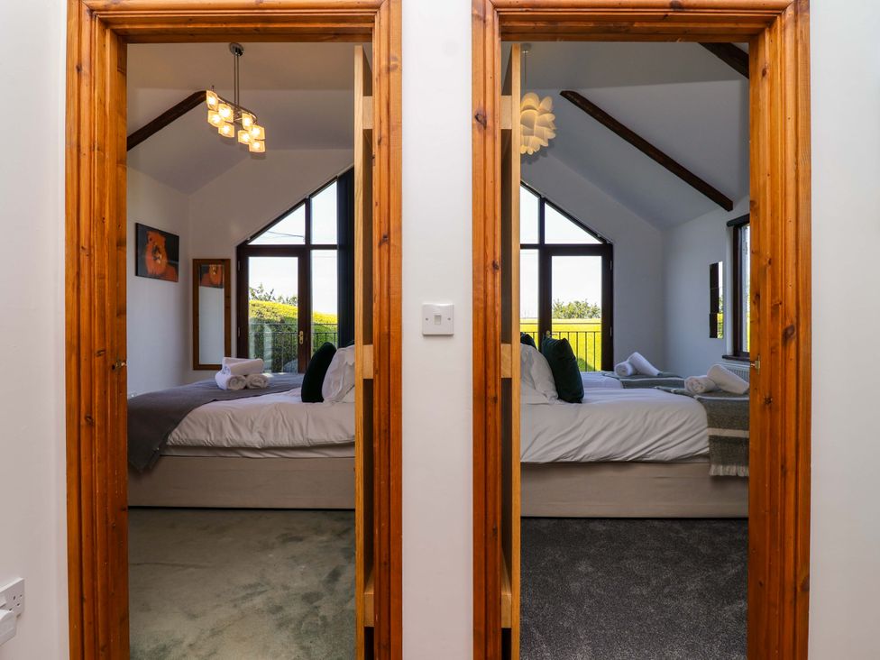 Two bedrooms with beds and towels at 1 Eastdon Cottages in Exeter