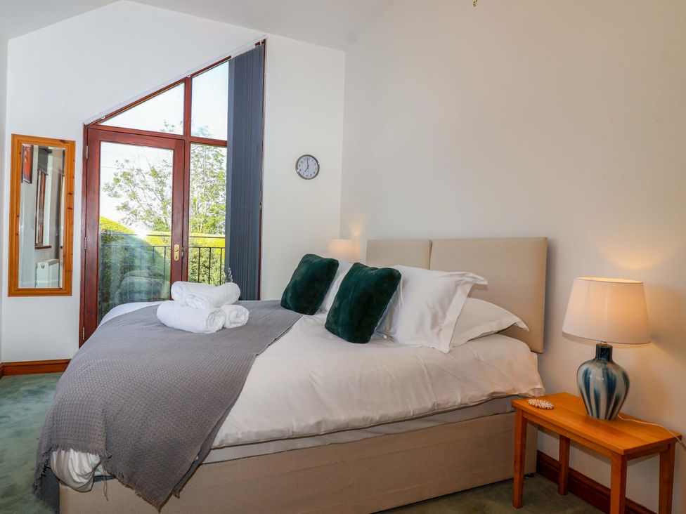 A bedroom with a bed and window at 1 Eastdon Cottages in Exeter