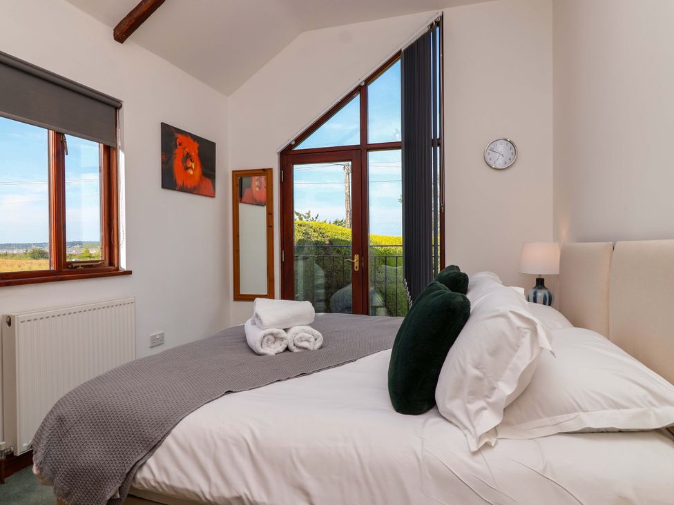 A bedroom with a bed and view of the outdoor at 1 Eastdon Cottages, Exeter