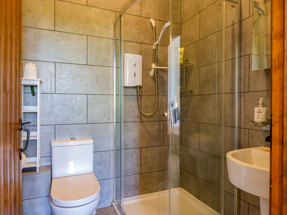A bathroom featuring a shower, toilet and sink at 1 Eastdon Cottages, Exeter