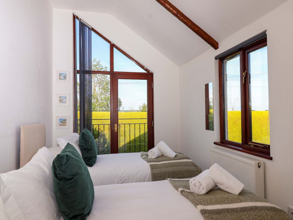 A bedroom with two beds and a view at 1 Eastdon Cottages in Exeter