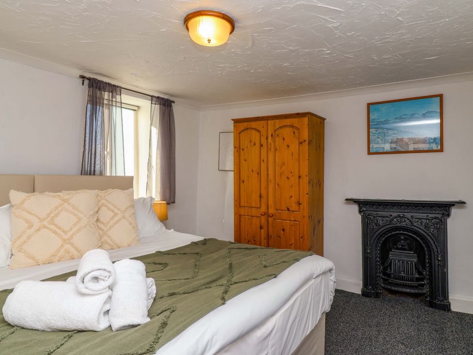 A bedroom with a bed and wardrobe at 1 Eastdon Cottages in Exeter