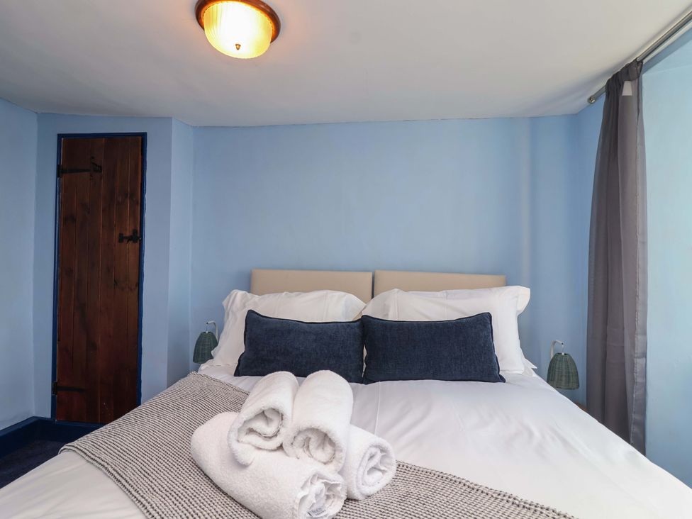 A bedroom with a bed and towels at 1 Eastdon Cottages in Exeter