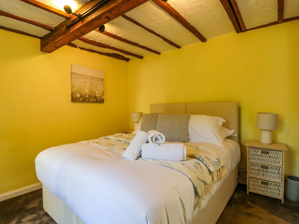 A bedroom with a bed and bedside table at 1 Eastdon Cottages Exeter