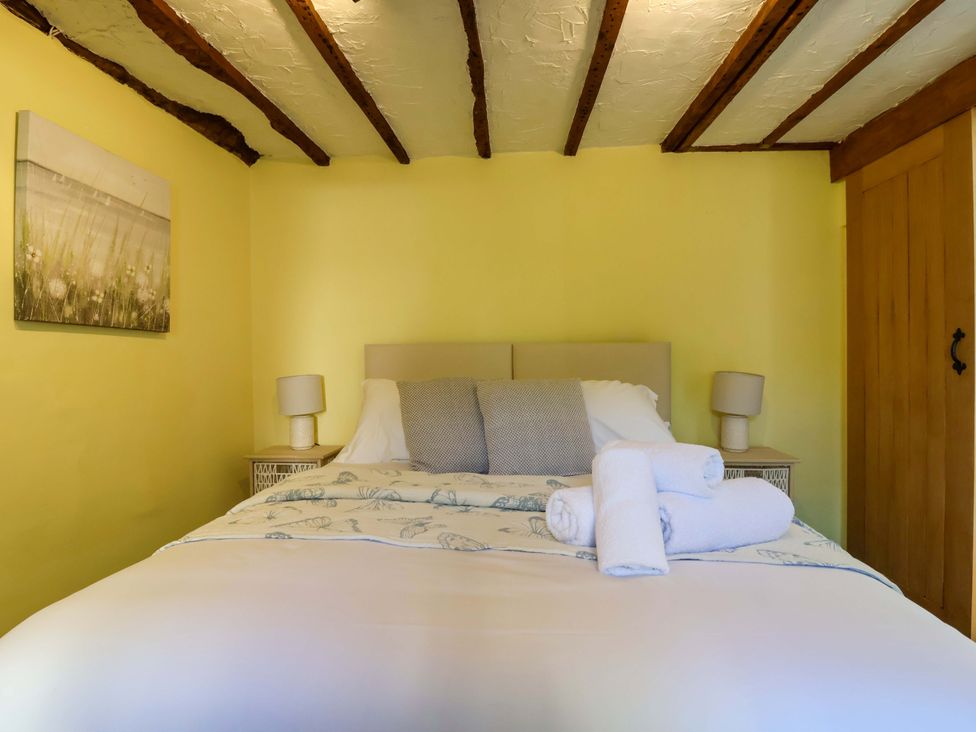 A bedroom with a bed and bedside lamps at 1 Eastdon Cottages in Exeter