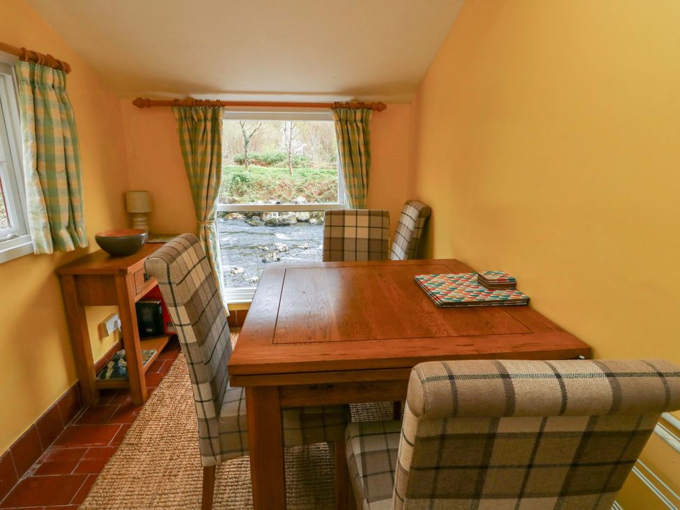 A dining room with a table and chairs at Riverbank Cottage in Beddgelert