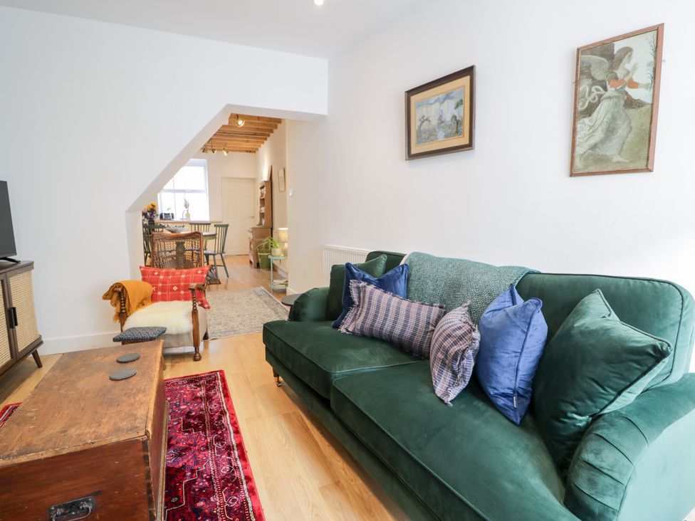 A living room with a green sofa and a coffee table at Derwen House in Llangollen