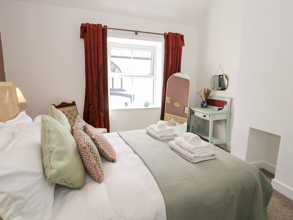 A bedroom with a bed and a dressing table at Derwen House, Llangollen