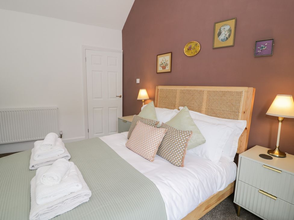 A bedroom with a bed and towels on the bed at Derwen House in Llangollen