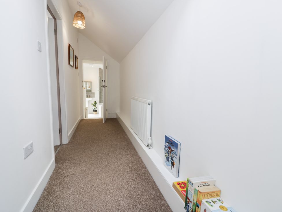 A hallway with books on the floor at Derwen House in Llangollen