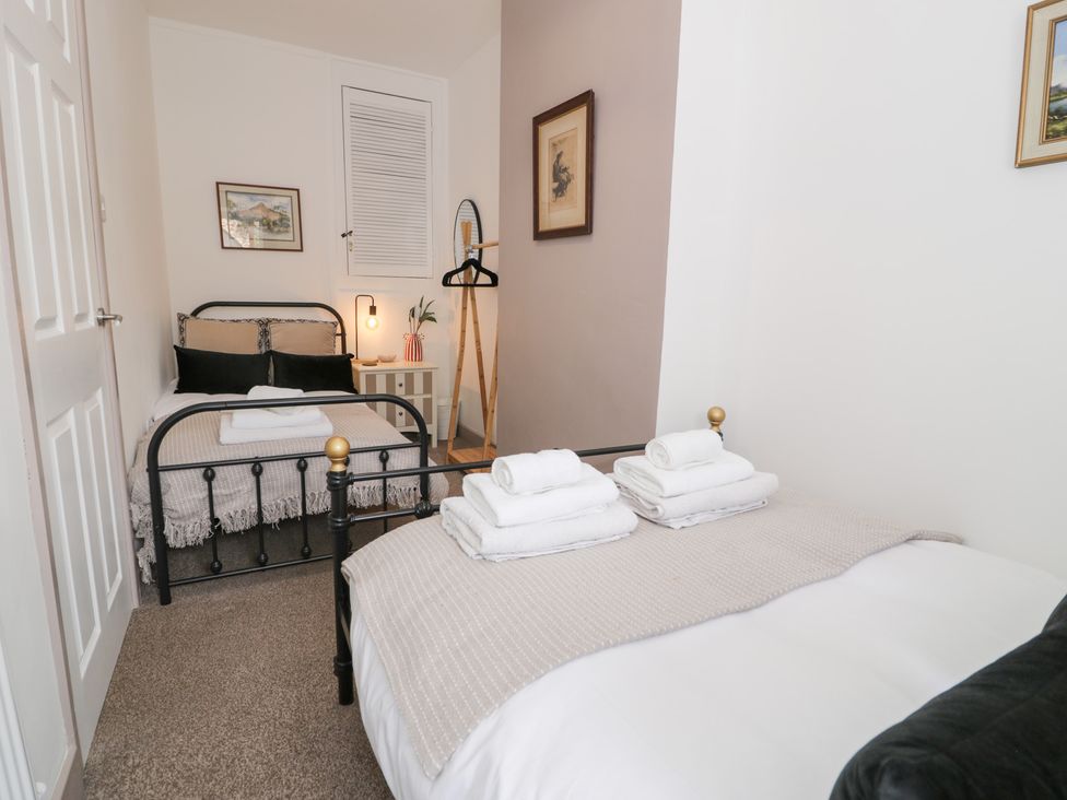 A bedroom with two beds and towels on the beds at Derwen House in Llangollen