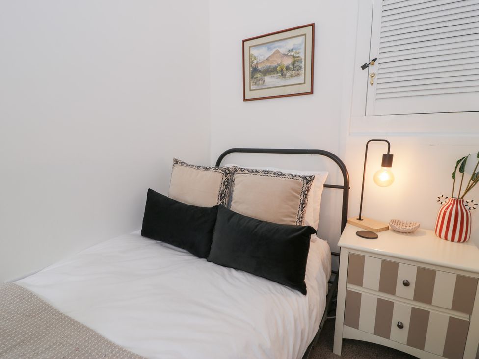 A bedroom with a bed and bedside table at Derwen House Llangollen