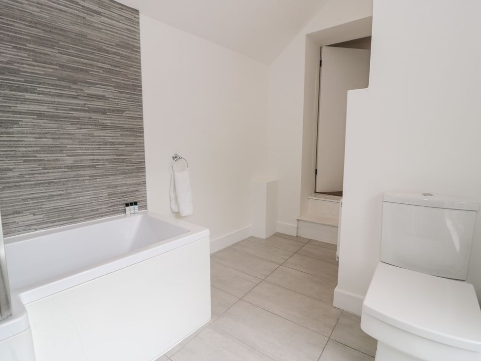 A bathroom with a bathtub and toilet at Derwen House Llangollen