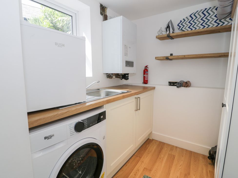 A utility room with a washing machine and sink at Derwen House in Llangollen