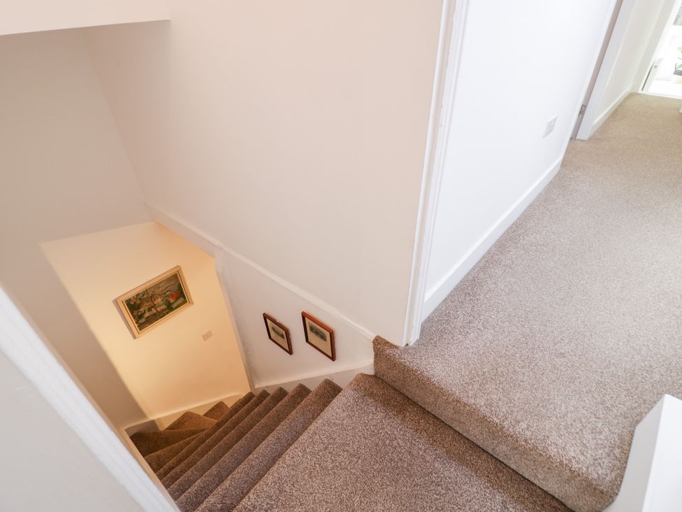 A staircase with paintings on the wall at Derwen House in Llangollen