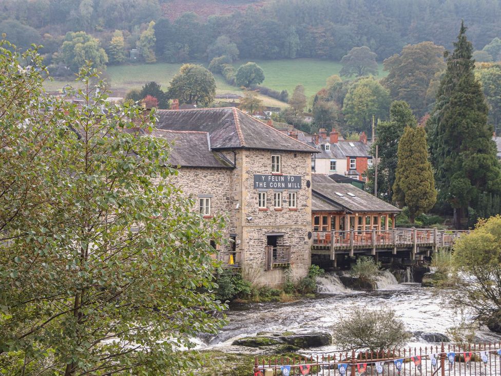 A mill building with a river nearby at Derwen House Llangollen