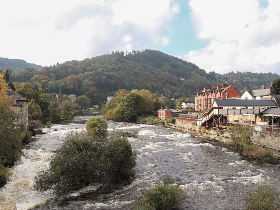 A view of a river with buildings and trees in Llangollen at Derwen House
