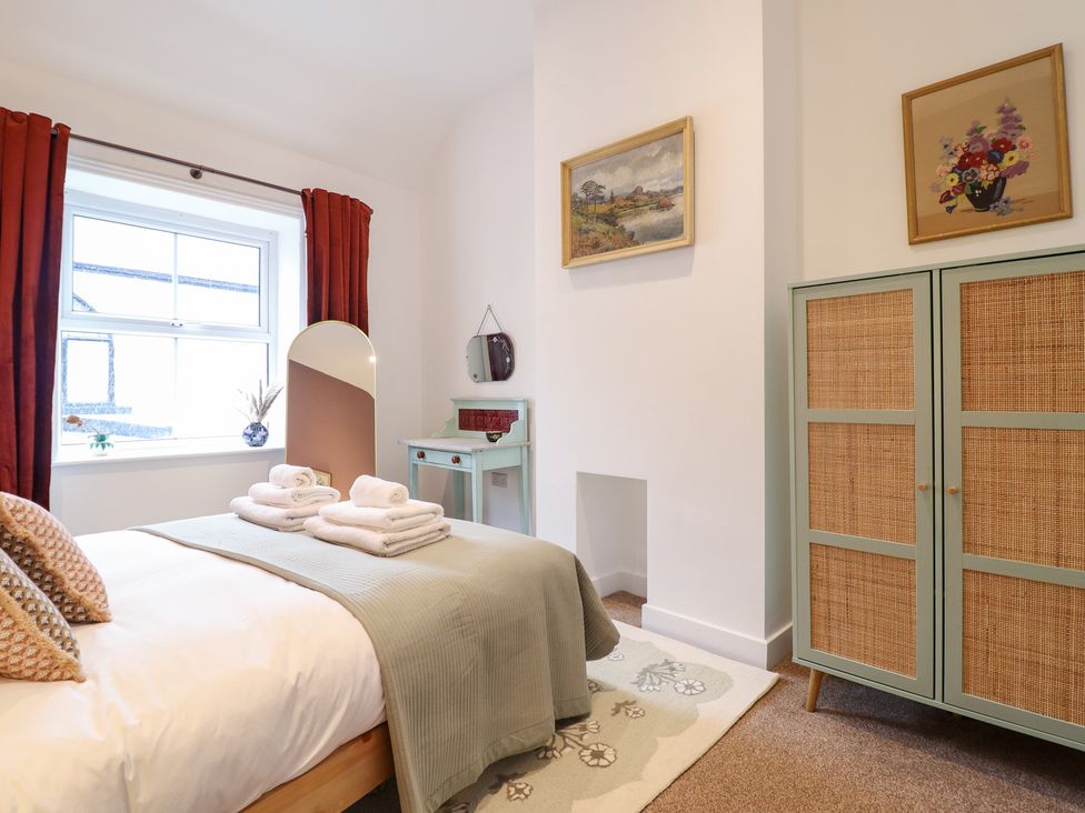 A bedroom with a bed and window at Derwen House in Llangollen