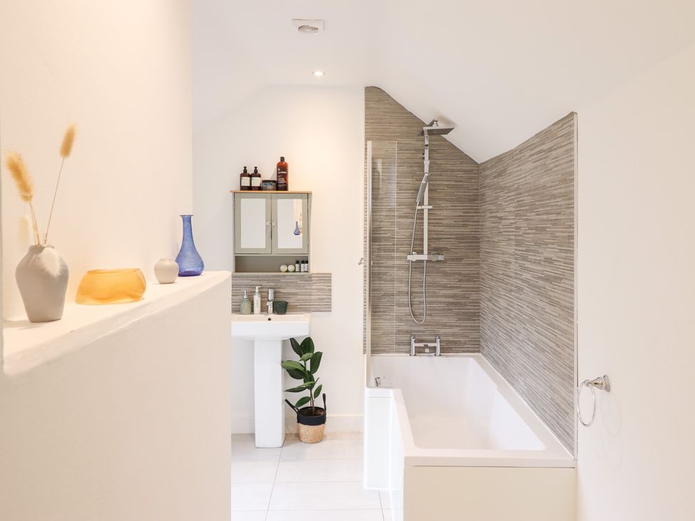 A bathroom with a bathtub and sink at Derwen House in Llangollen
