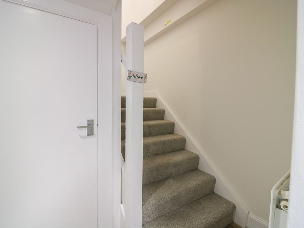 A hallway with stairs and a door at 21A High Street, Jedburgh