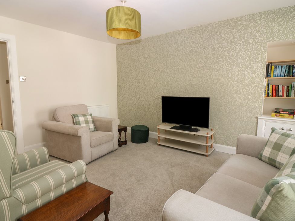 A living room with a television and seating at 21A High Street, Jedburgh