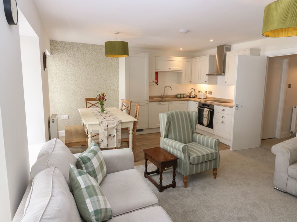 A living room with a sofa and dining area at 21A High Street in Jedburgh