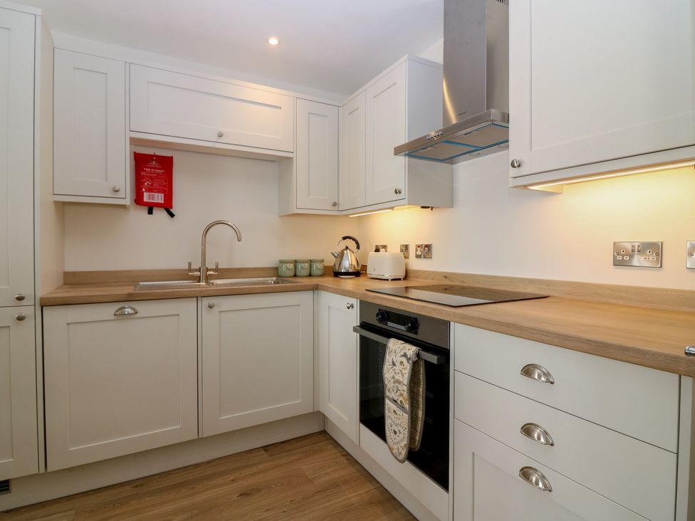 A kitchen with cabinets and appliances at 21A High Street in Jedburgh