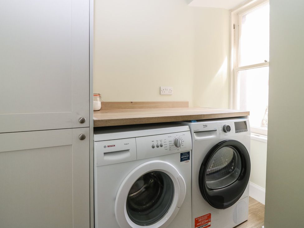 A laundry room with a washing machine and dryer at 21A High Street in Jedburgh