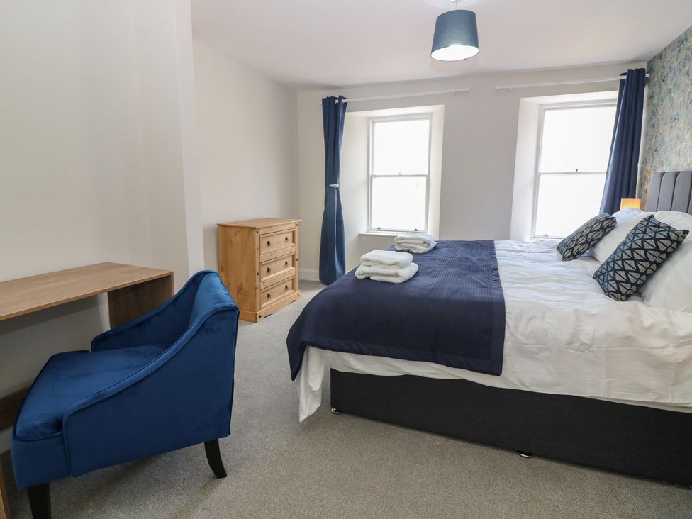 A bedroom with a bed, desk, chair, and dresser at 21A High Street in Jedburgh