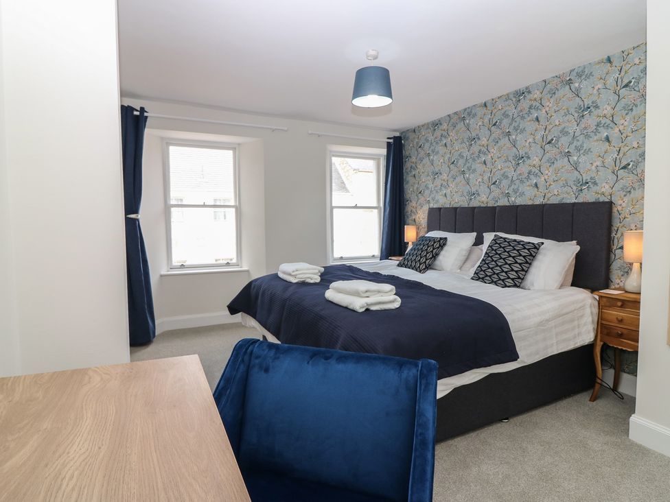 A bedroom with a bed and windows at 21A High Street Jedburgh