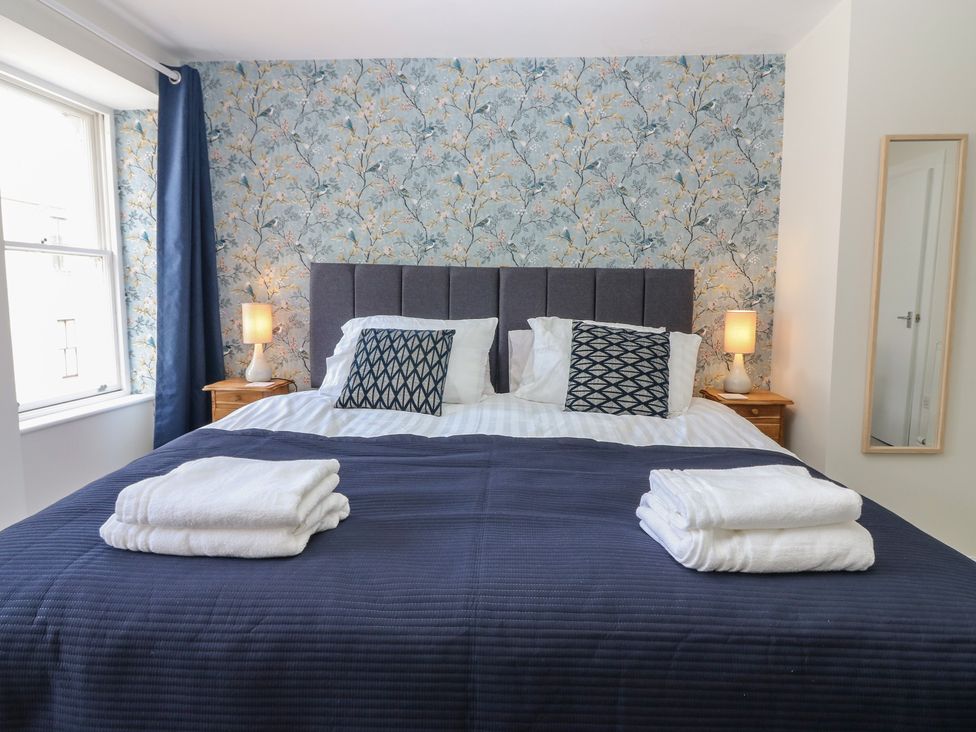 A bedroom with a bed and bedside tables at 21A High Street in Jedburgh